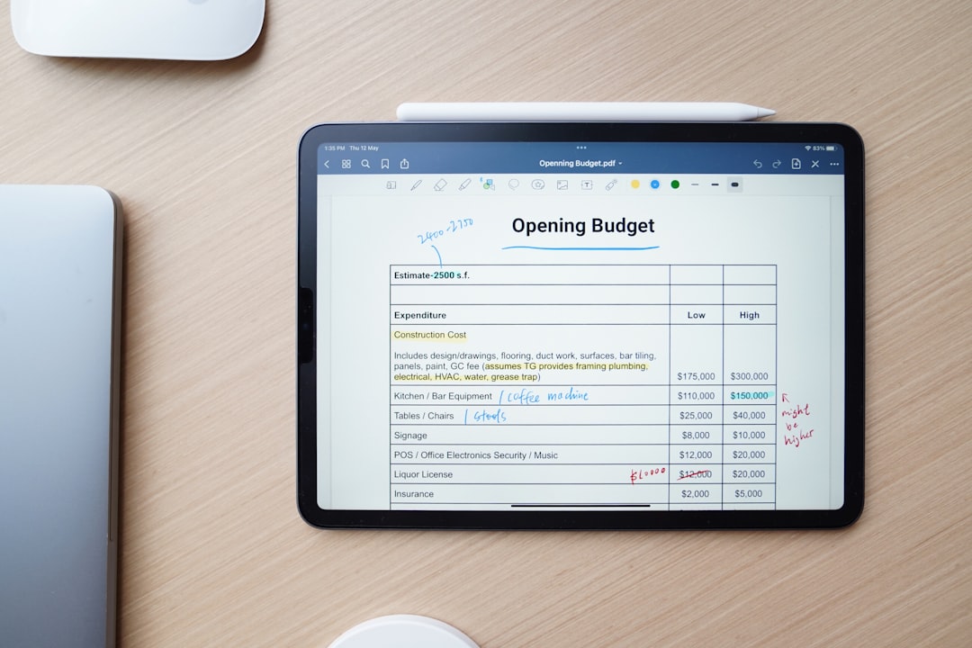 Med spa owner reviewing a marketing budget breakdown on a laptop at their front desk