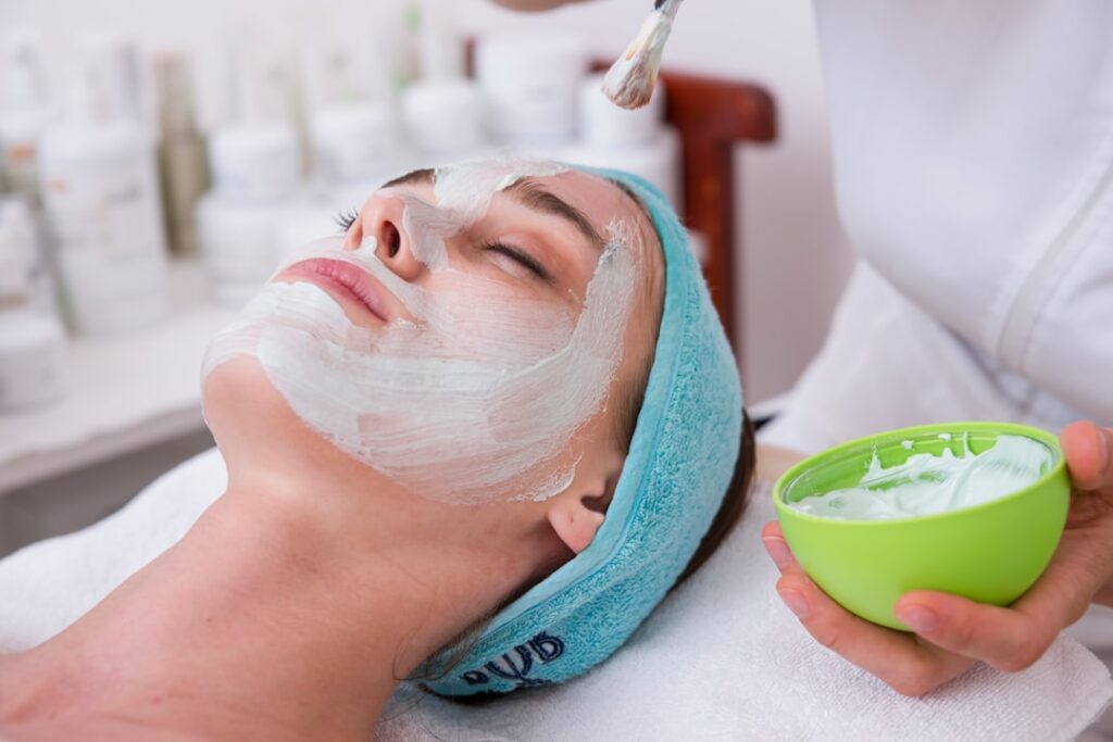 Esthetician performing a facial treatment in a med spa treatment room