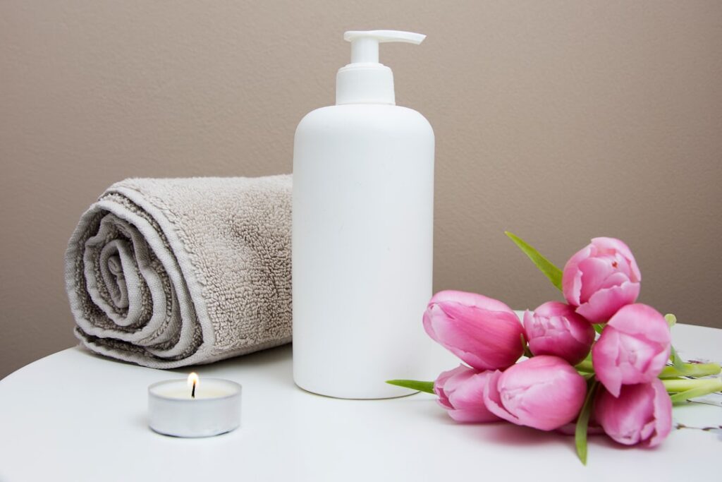 Spa candles and rolled towels in a warm luxury setting